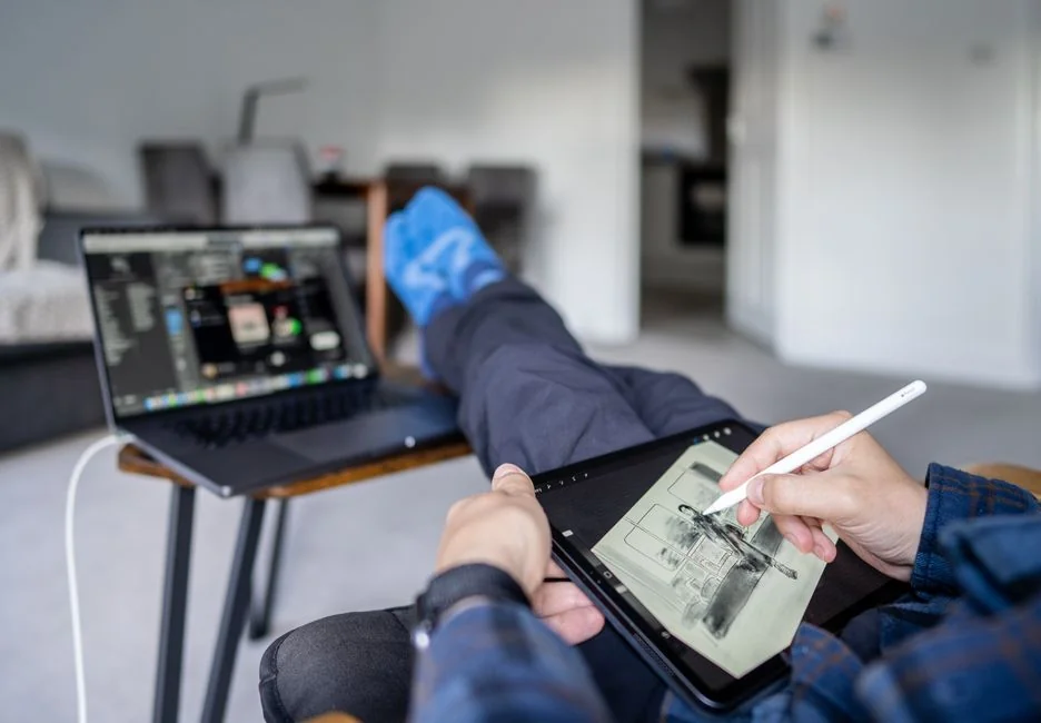 A tidy desk setting with a laptop showing a stock photo website and a smartphone.